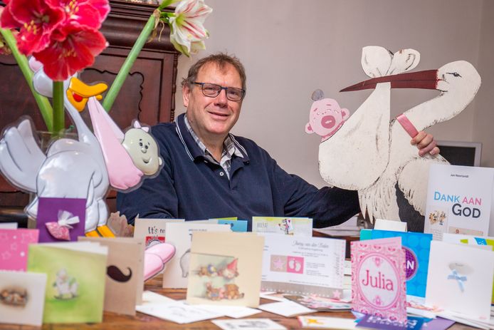 Jan Noorlandt tussen de geboortekaartjes waarover hij het boek Dank aan God schreef.