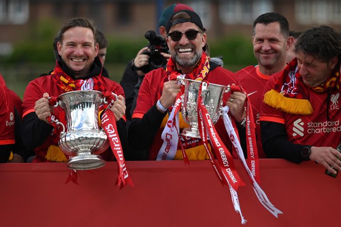 Pepijn Lijnders met de FA Cup en Jürgen Klopp met de League Cup bij de bustour van Liverpool door het centrum van de stad.