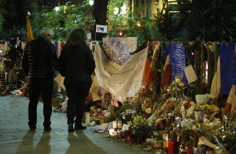 Mensen leggen bloemen neer bij Bataclan, de concertzaal in Parijs waar op 13 november 2015 een aanslag werd gepleegd. Beeld AFP