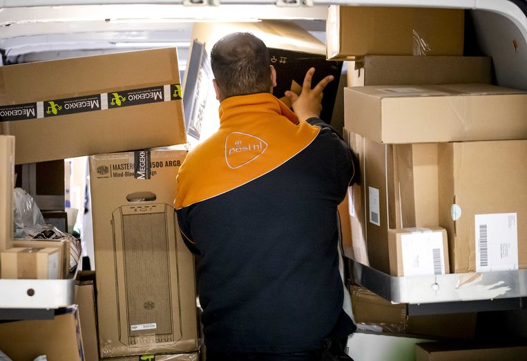 Een medewerker van post- en pakketbezorger PostNL sorteert pakketjes in het pakkettensorteercentrum.  Beeld ANP, Sem van der Wal 