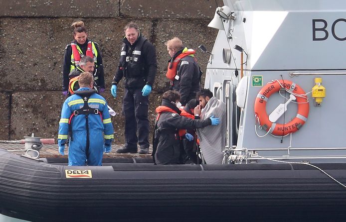 Een migrant wordt door de Engelse kustwacht aan wal gebracht in Dover.