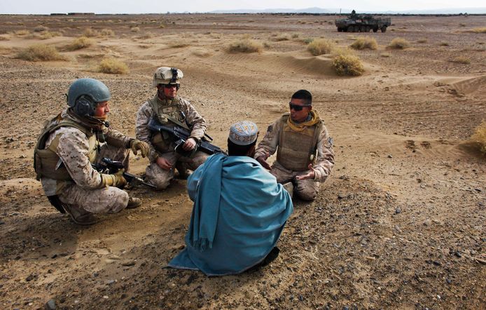 Twee Amerikaanse militairen spreken met een Afghaanse man in 2009 met behulp van een lokale vertaler (uiterst rechts).