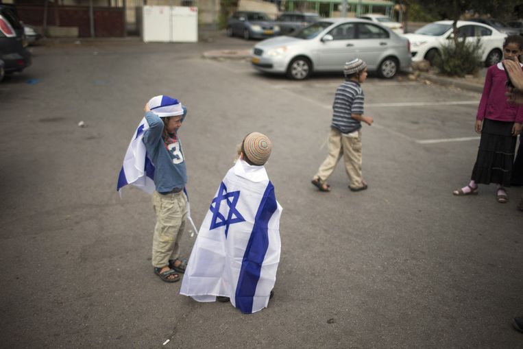 Kinderen spelen met Israëlische vlaggen tijdens een demonstratie tegen de vrijlating van Palestijnse gevangenen bij de Ayalon-gevangenis. Beeld GETTY