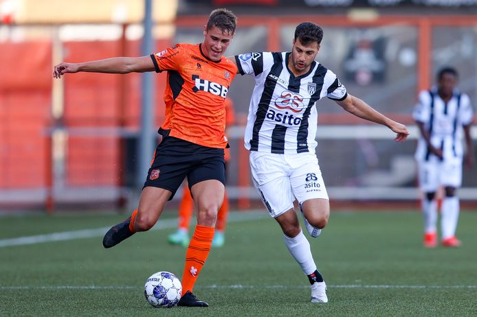 Micky van de Ven in duel met Heracles-speler Sinan Bakis.