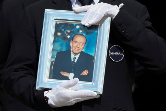 Un cavalletto contiene una foto di Berlusconi che passa davanti alla bara durante i funerali di Stato.