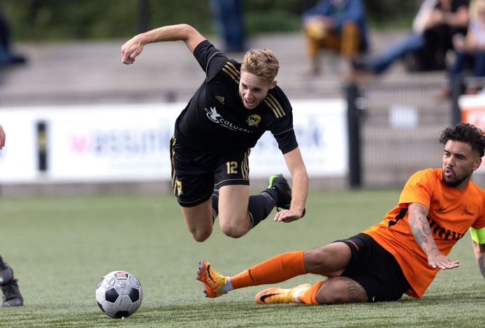FC Winterswijk-speler Nick Jansen gaat onderuit in een duel met Voorwaarts-aanvoerder Nino Wattimena.