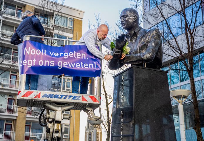 Vanaf een hoogwerker legt Robert Simons (Leefbaar Rotterdam) bloemen bij het beeld van Pim Fortuyn.