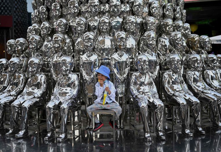 Een jongetje zit tussen sculpturen tijdens de Chinese Dag van het Kind op 1 juni, in Peking. Beeld AFP