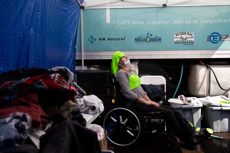 Una donna in un centro di refrigerazione indossa abiti freddi sulla testa e sul petto.  Immagine del Washington Post