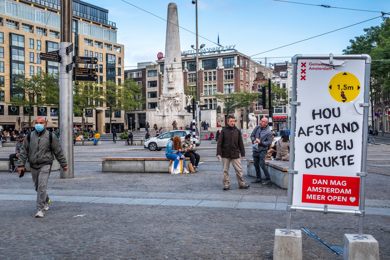 Een bord roept op tot social distancing, op De Dam in Amsterdam. Beeld Joris Van Gennip