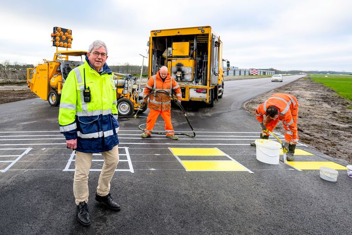 Havenmeester Jan Voeten bij de wegwerkers op Breda Airport. Het vliegveld krijgt geasfalteerde taxibanen.
