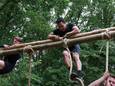 Klauterende deelnemers van een eerdere obstacle run in Nederland. Ook in Raalte komt er zo'n constructie waar overheen geklommen moet worden.