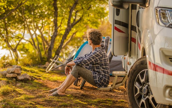 Retired Woman in Her 60s Enjoying Her Vacation with Camper Van. Senior Outdoor Recreation Theme.