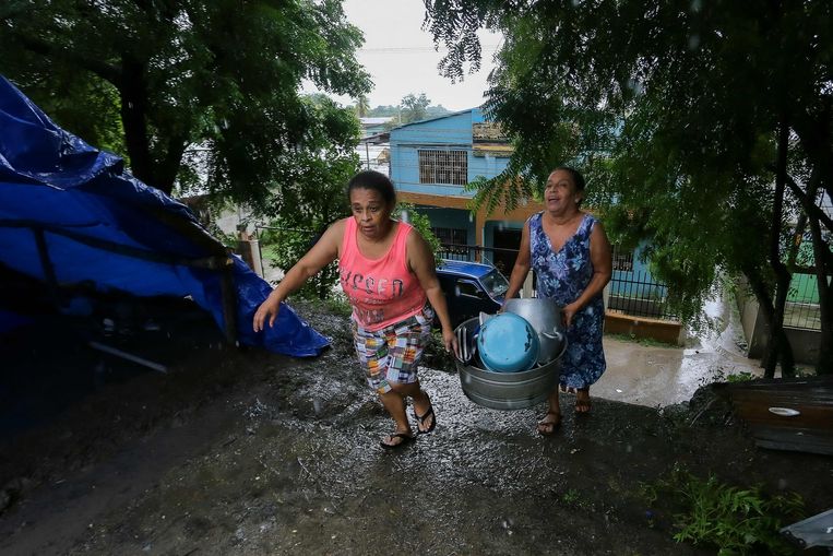 Twee vrouwen tijdens een overstroming in Honduras vorig jaar. Midden-Amerika is de afgelopen jaren zwaar getroffen door stormen, waar volgens experts La Niña en El Niño grote invloed op hebben. Beeld AFP