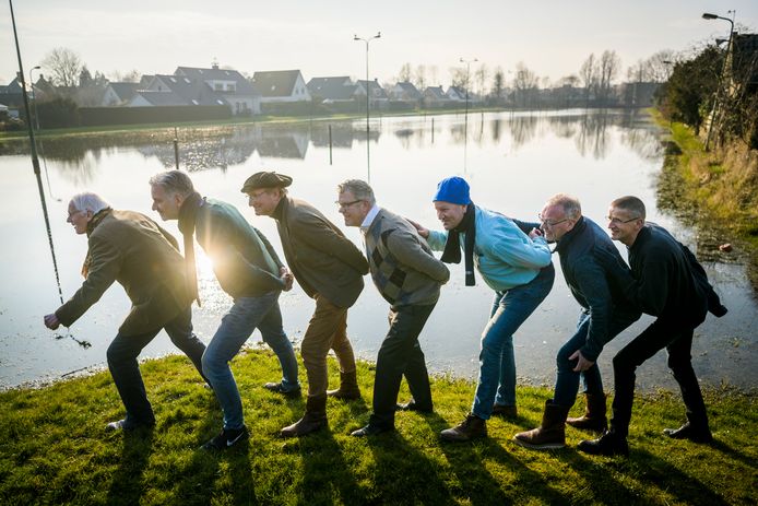 Leden van de Koninklijke IJsclub Dockum, de oudste ijsvereniging van Nederland, poseren bij hun schaatsbaan, waar vooralsnog geen millimeter ijs op ligt. De verwachting is dat volgende week donderdag overal in Nederland kan worden geschaatst. Vlnr: Ids Bergsma, Jan-Willem Hamstra, Minze van den Akker, Jack Raadsma, Ynze Elzinga, Dick Zeinstra en Anne van der Meulen. Foto: Kees van de Veen