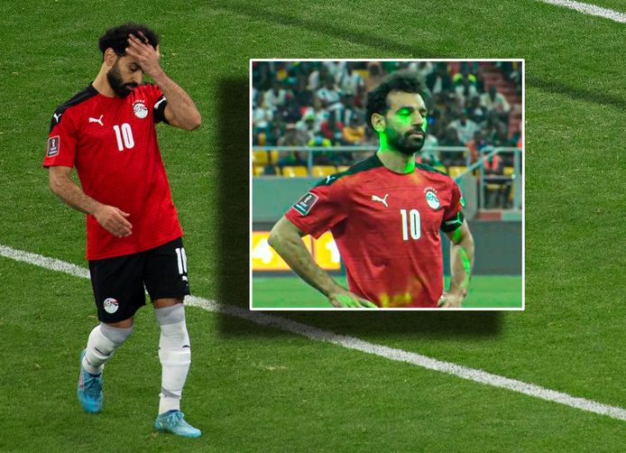 Mohamed Salah treurt na zijn gemiste strafschop. Inzet: de talloze laserpennen die vanuit het publiek op hem worden gericht.