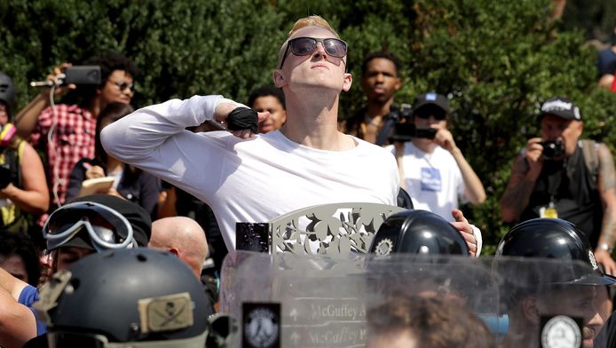 Een demonstrant maakt een snijgebaar bij zijn keel tijdens de extreemrechtse mars in Charlottesville.