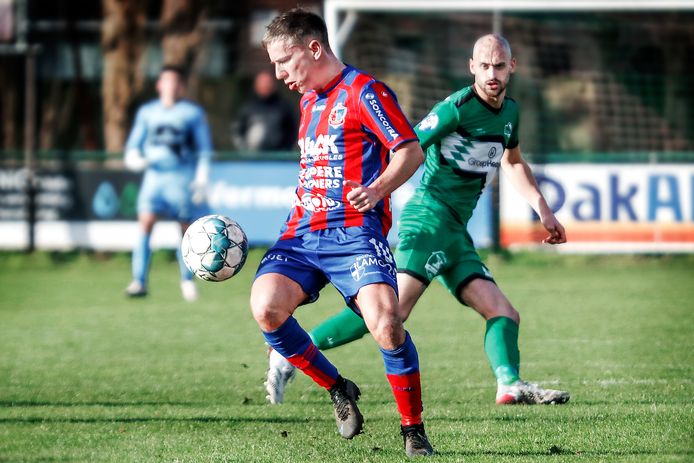 Jérémie Cremers (l.) op KVV Zelzate in duel met  Pieter Grootaert.