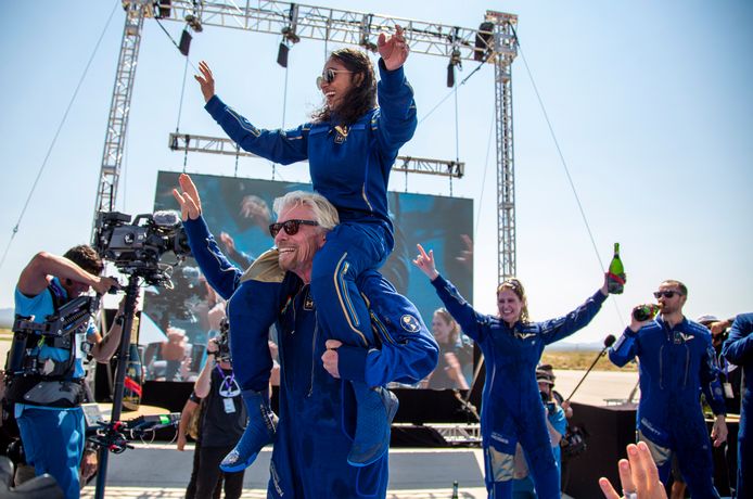 Euforisch viert Richard Branson met medebemanningslid Sirisha Bandla op zijn nek de terugkeer na hun eerste ruimtevlucht.