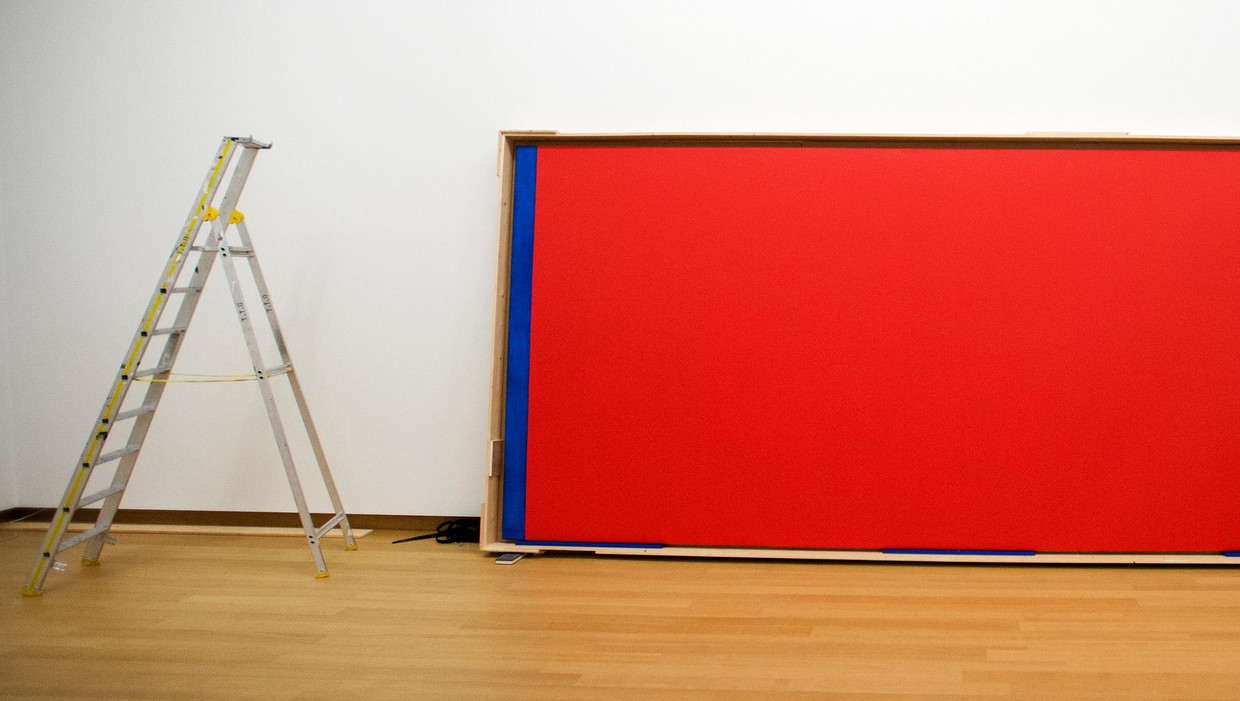 Een beveiliger bij het schilderij Who is afraid of Red, Yellow and Blue van Barnett Newman dat in 2014 wordt opgehangen in het Stedelijk Museum. Beeld anp