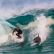 Terwijl bloeddorstige haaien op de loer liggen, maakt gracieuze surfer iets ongelooflijks mee