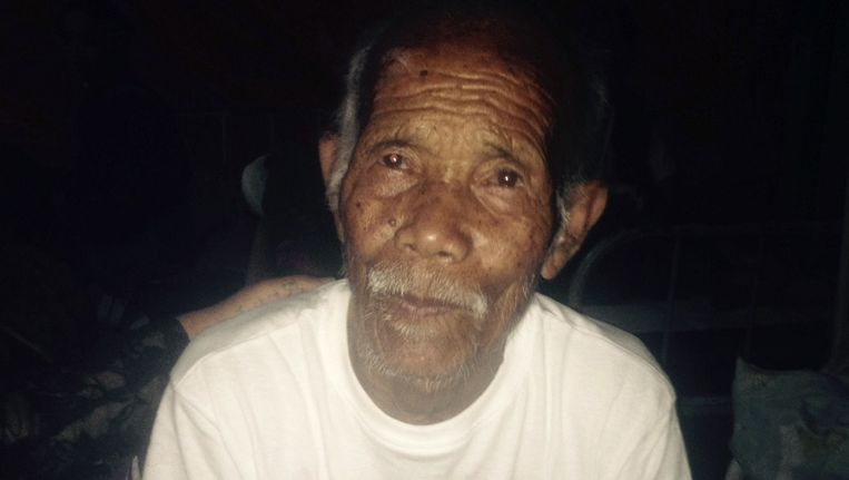 Funchu Tamang, een man van 101 jaar oud, is een week na de aardbeving levend onder het puin vandaan gehaald. Hij zit hier in het ziekenhuis op een bed. Beeld afp