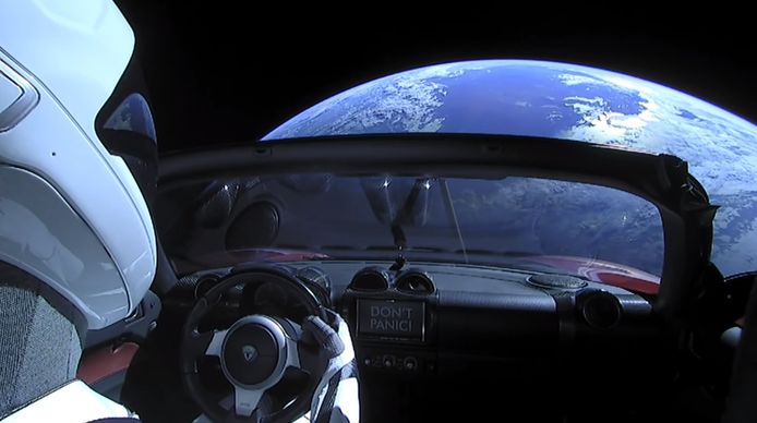 Het uitzicht van de rode Tesla Roadster in de ruimte.