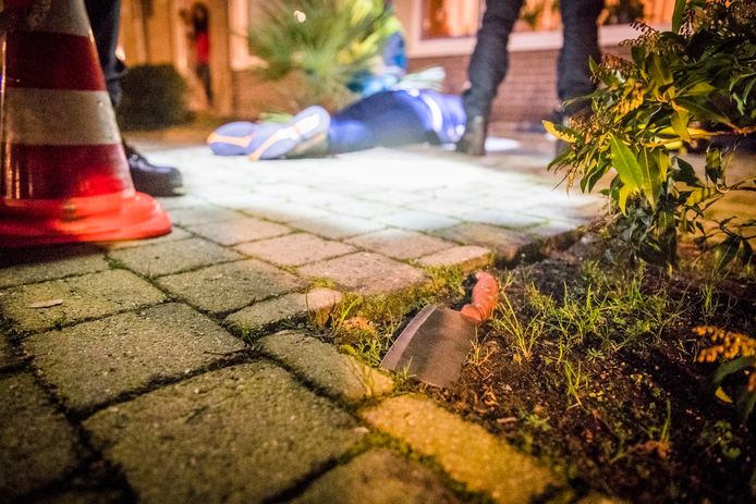 De overvaller wordt ingerekend in een voortuin in Eindhoven. Op de voorgrond het mes waarmee op Ahmad werd ingehakt.