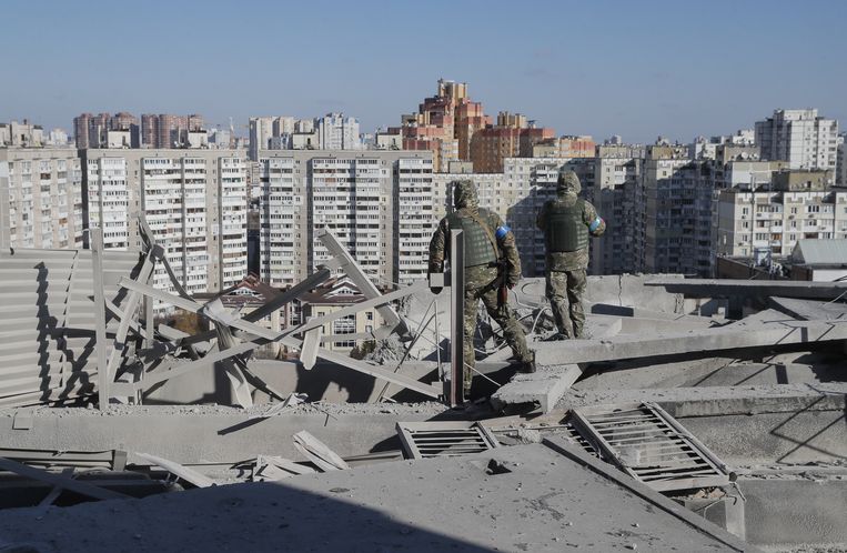 Oekraïense militairen nemen de schade op bij een appartementencomplex in Kiev dat in de nacht van woensdag op donderdag werd gebombardeerd.  Beeld ANP / EPA