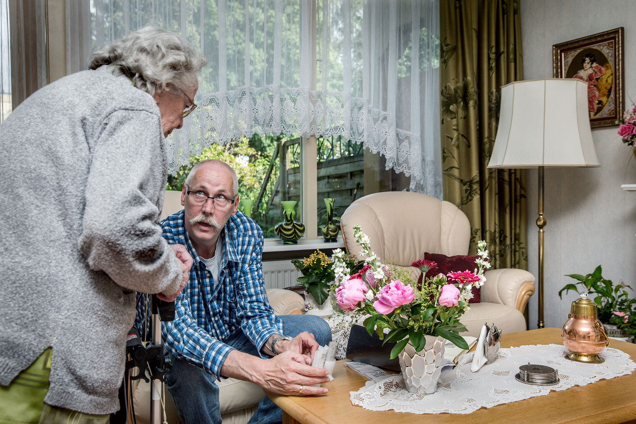 Zorgmedewerker Theo Panneman brengt een patiënt haar medicijnen. Beeld Jean-Pierre Jans