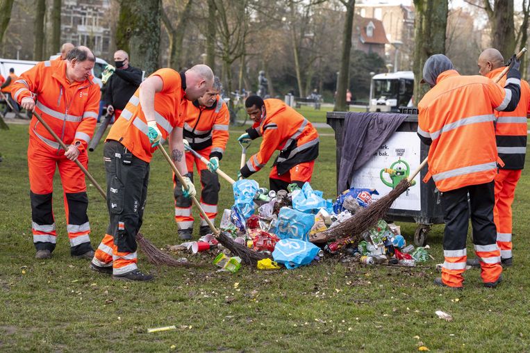 Opruimen in het Amsterdamse Vondelpark. De politie greep eerder in omdat het in het park te druk was en de coronamaatregelen niet werden nageleefd. Beeld ANP
