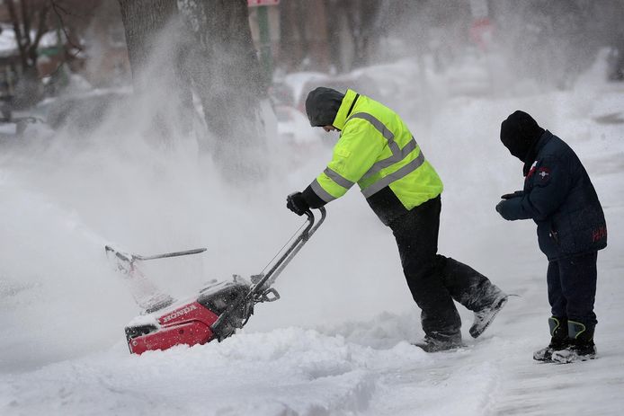 In Chicago probeert een man met een sneeuwruimer de weg begaanbaar te maken. In de stad en omgeving viel tussen de 10 en 25 centimeter sneeuw.