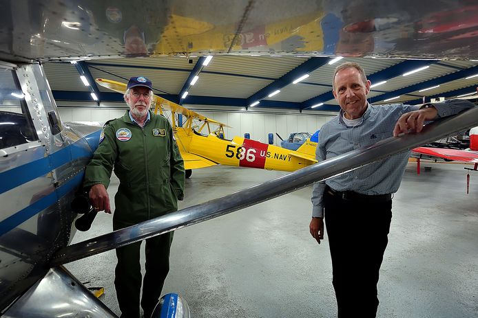 Voorzitter Hans van Arkel (l) en Ton van Meer bij de zilverkleurige Luscombe Silvair en op de achtergrond de gele Boeing Stearman.