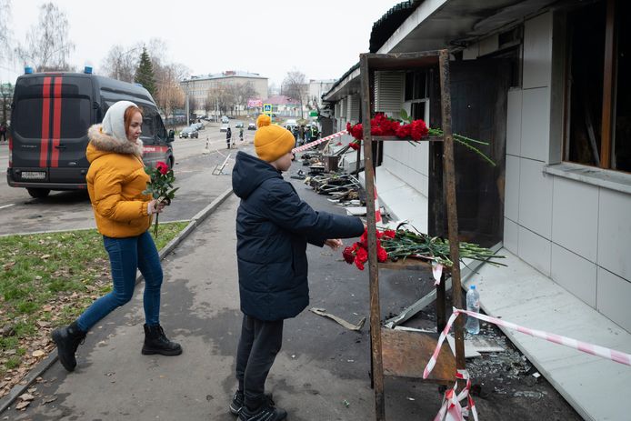 Burgers tonen hun steun aan de slachtoffers van de dodelijke brand en leggen bloemen bij de ravage van de Russische nachtclub.