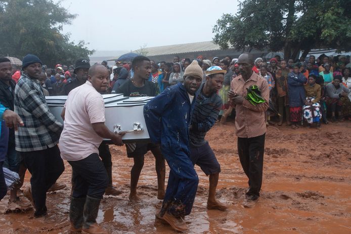 Mannen dragen een kist naar een massabegrafenis van slachtoffers van een landverschuiving in Blantyre, Malawi.