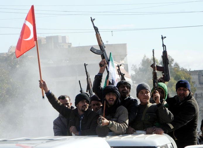 Soldaten van het Vrije Syrische Leger zwaaien met hun wapens en de Turkse vlag in Azez.