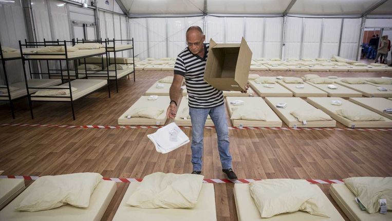 Medewerkers van het aanmeldcentrum in Ter Apel richten een barak in ter uitbreiding voor de eerste opvang van de asielzoekers. Beeld anp