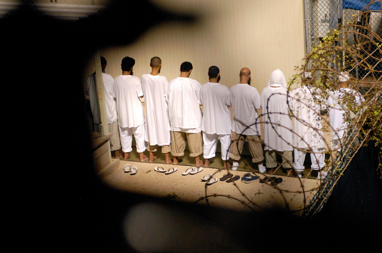 Biddende gevangenen in Camp Delta op de marinebasis Guantánamo Bay. Beeld REUTERS