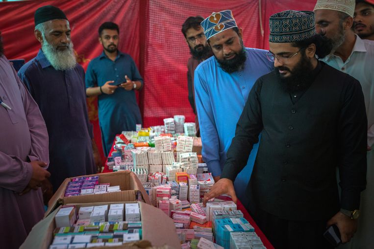 De Pakistaanse imam Razi Hussaini inspecteert de verstrekking van gratis medicijnen door zijn  radicaal-islamitische partij Tehreek-e-Labbaik Pakistan (TLP) in een arme wijk van de havenstad Karachi . Beeld Asim Hafeez