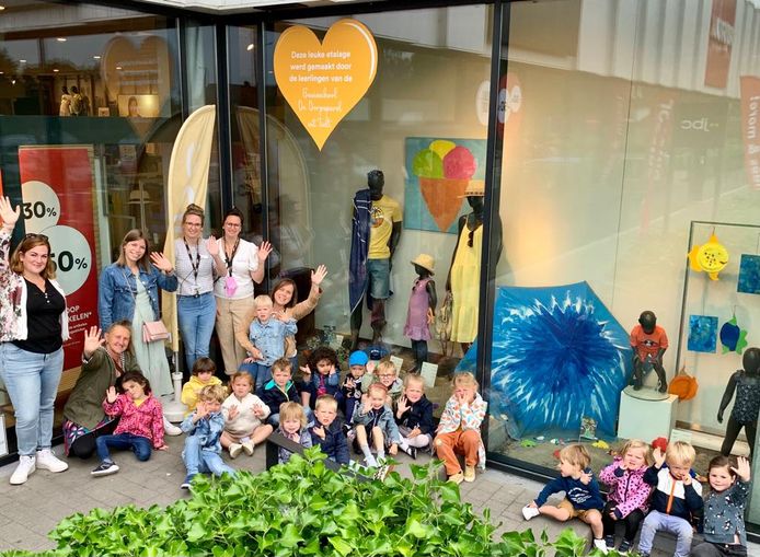 De kleutertjes van De Dorpsparel mochten de etalage van de JBC in Tielt onder handen nemen. Je ziet kunstwerkjes van (onder andere) ijsjes, een parasol, zon, zand en zee in de etalage.