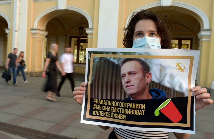 Een vrouw in Sint Petersburg steunt oppositieleider Navalny na een mogelijke aanslag op diens leven.