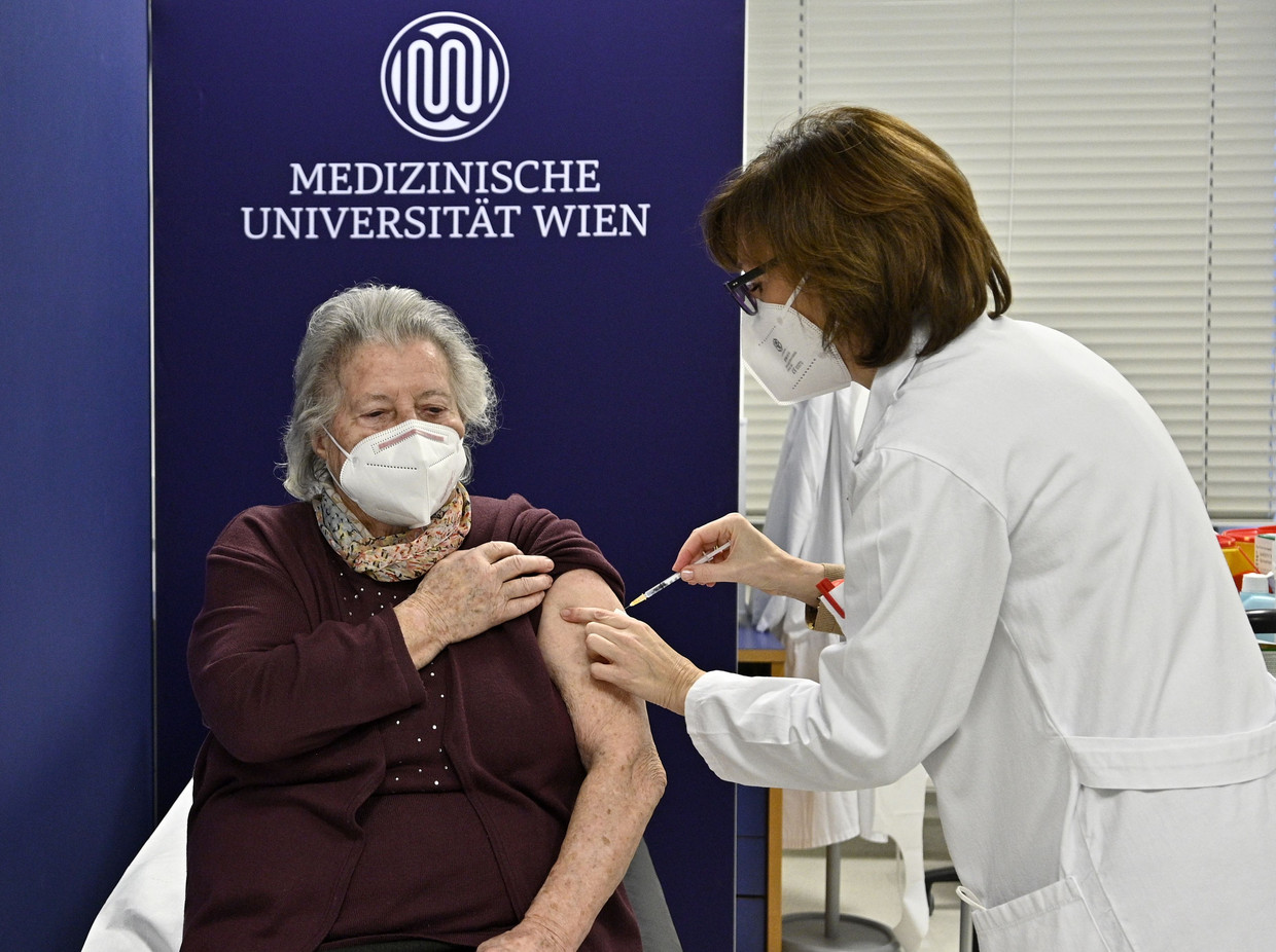 Een Oostenrijkse vrouw van 80 krijgt haar tweede prik.  Beeld AFP