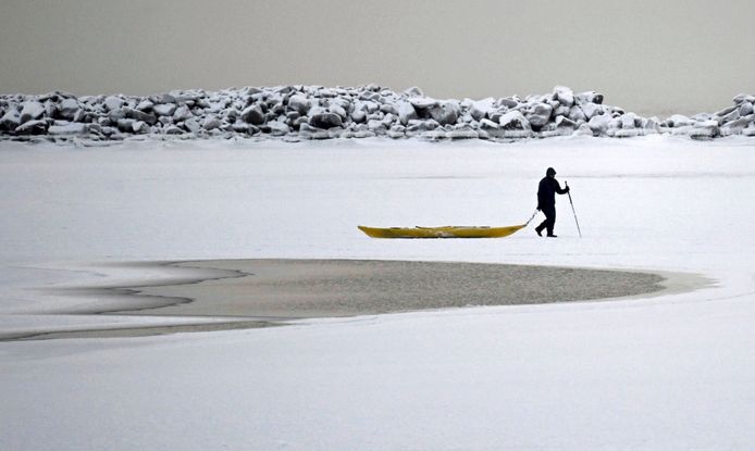 Een man wandelt op een bevroren meer in de buurt van Helsinki.