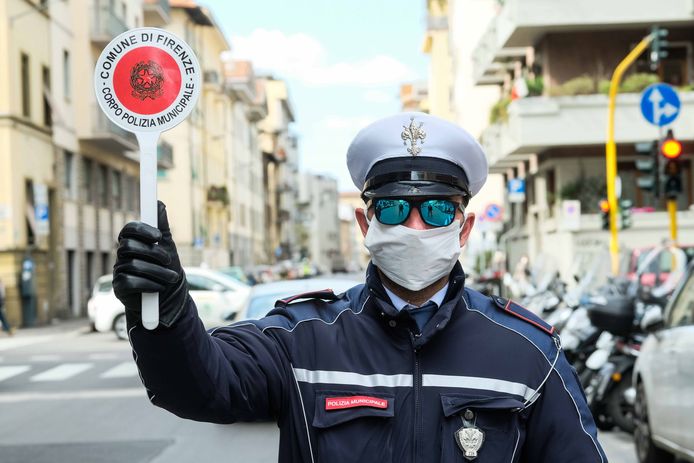 Een agent in Firenze (Italië) controleert voorbijgangers op niet-essientiële verplaatsingen.