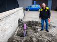 Jan van der Poel bij het gat waar de 42 kabels via de grond het gebouw ingaan.