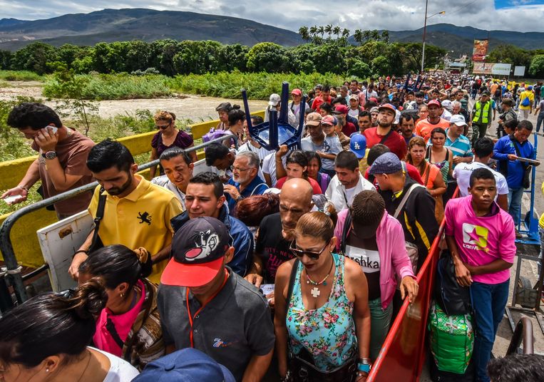 Venezolaanse dagloners trekken ­richting Cúcuta in ­Colombia via de Simon Bolívar-brug. Dagelijks zijn het er zo’n 25.000. Beeld AFP