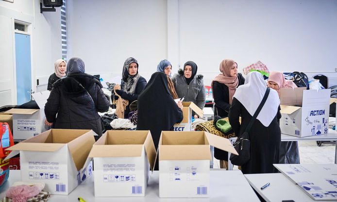 Turkse vrouwen pakken ingezamelde kleding, dekens en spullen in voor transport naar het rampgebied.