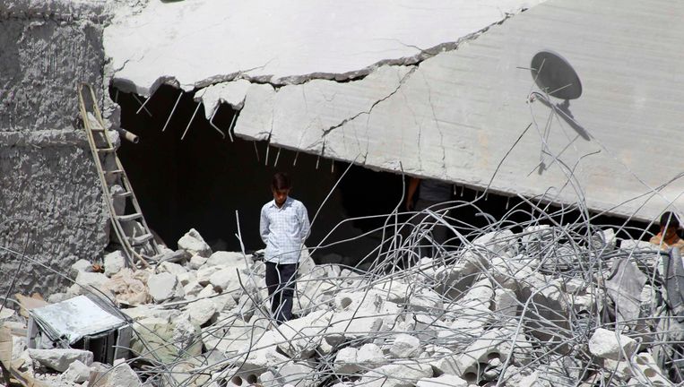 Een man in Idlib, Syrië, tussen de puinhopen van een gebouw dat door Amerikaanse bommen is geraakt. Beeld reuters