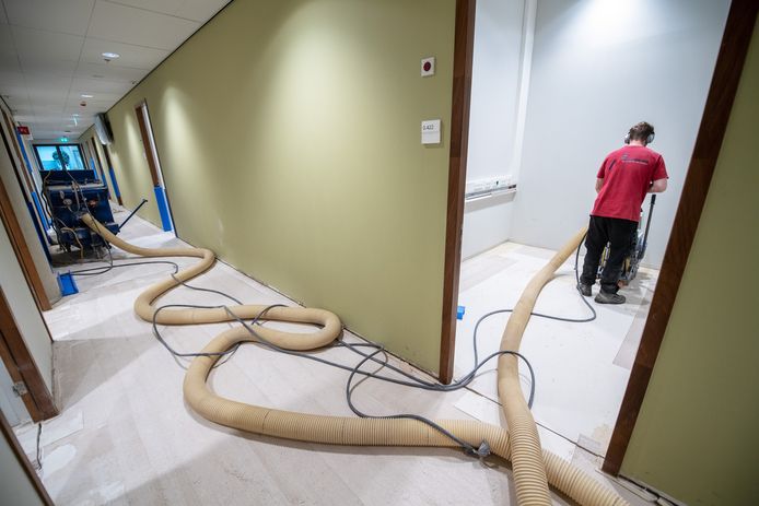 Werkzaamheden in het Maria Montessorigebouw om de waterschade te herstellen. De vloeren worden vacuüm gezogen en afgeschraapt.