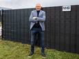 Tonnie van der Heijden bij zijn uitvinding: zonnepalen ingevlochten in hekwerk. Links om stroom op te wekken, rechts om zwembaden te verwarmen.